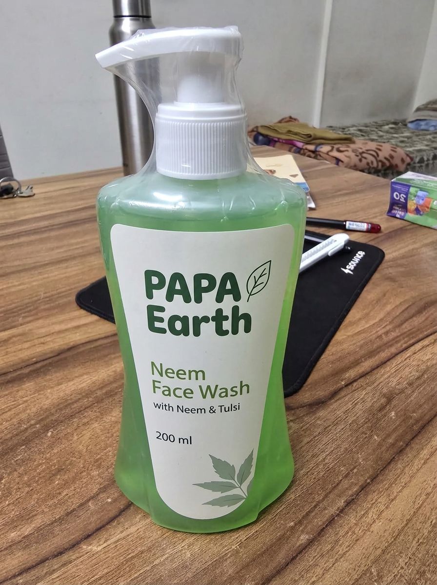 Original phone photo of the same face wash bottle on a wooden desk